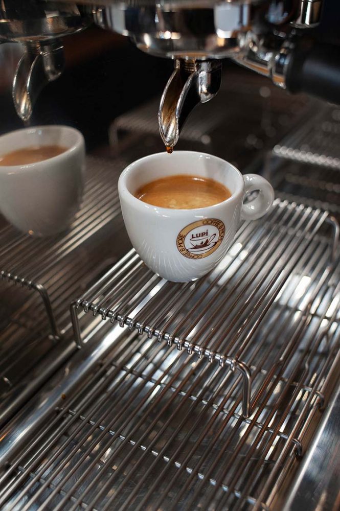 Een kopje espresso onder de machine van Lupi Coffee een bedrijf van Hossein Akef